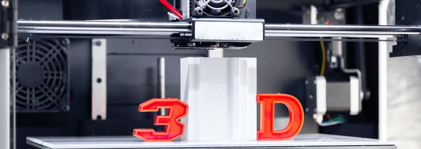 Zbliżenie na głowicę drukującą drukarki 3D oraz na element wydrukowany