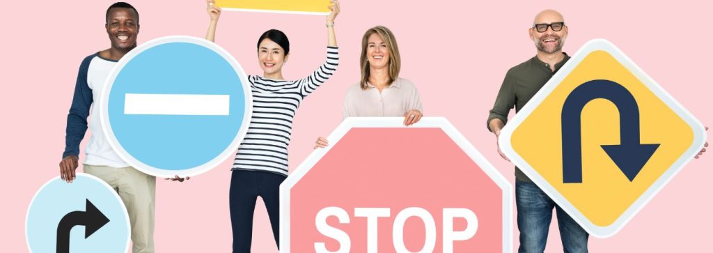 Kobiety i mężczyźni różnych ras trzymający znaki drogowe