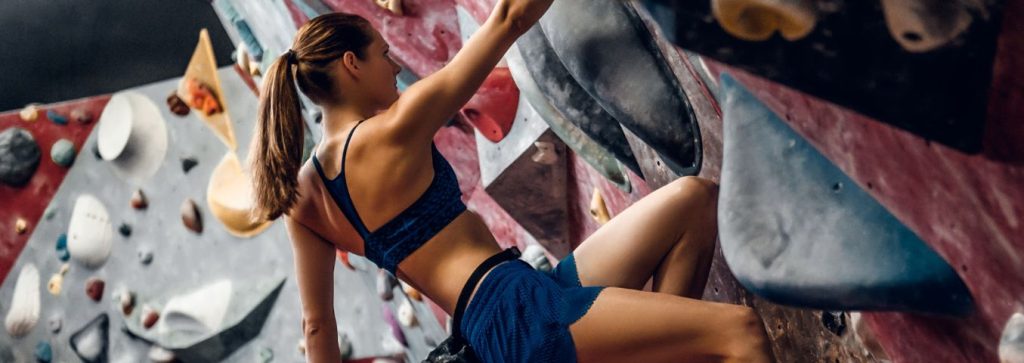 kobieta uprawiająca wspinaczkę w obiekcie zamkniętym