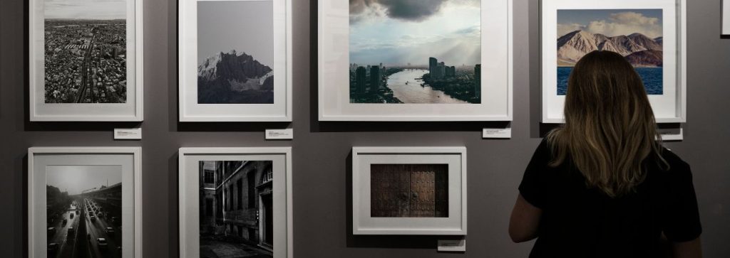 Kobieta stojąca przed wystawą zdjęć