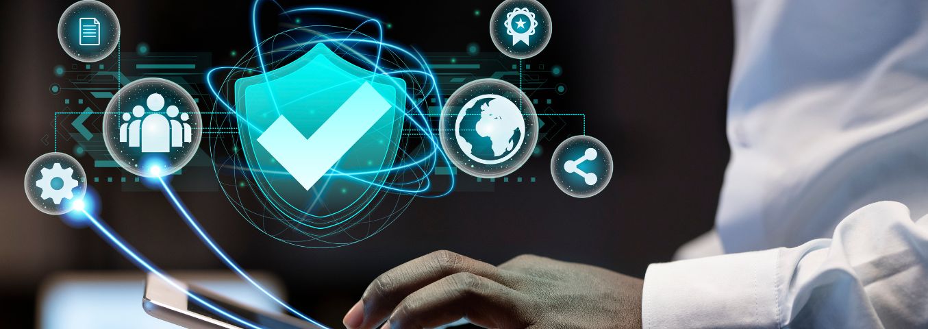 Zbliżenie na dłonie mężczyzny korzystającego z tabletu. Nad tabletem widnieją m.in. symbole znaku sukcesu