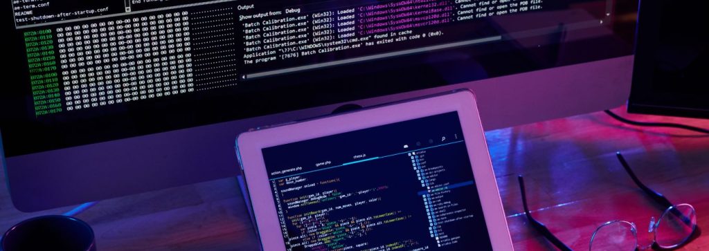 Monitory programisty na biurku.