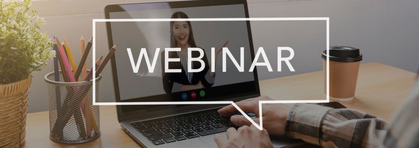 Laptop leżący na biurku z napisem webinar