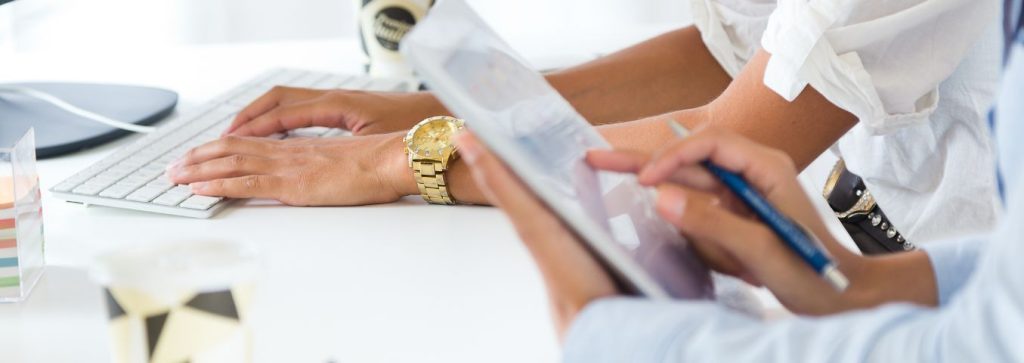 dłonie przy komputerze i tablecie